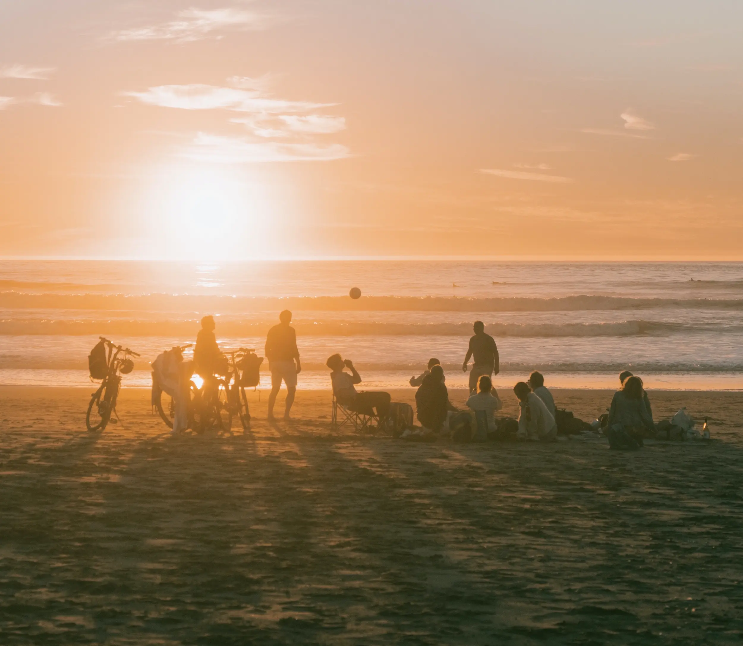 People gathering at the beach at sunset